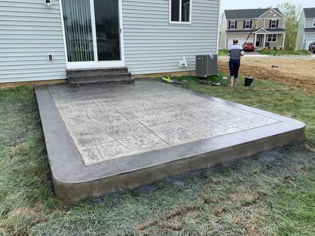 Custom decorative patio with rounded edges and stamped, colored concrete