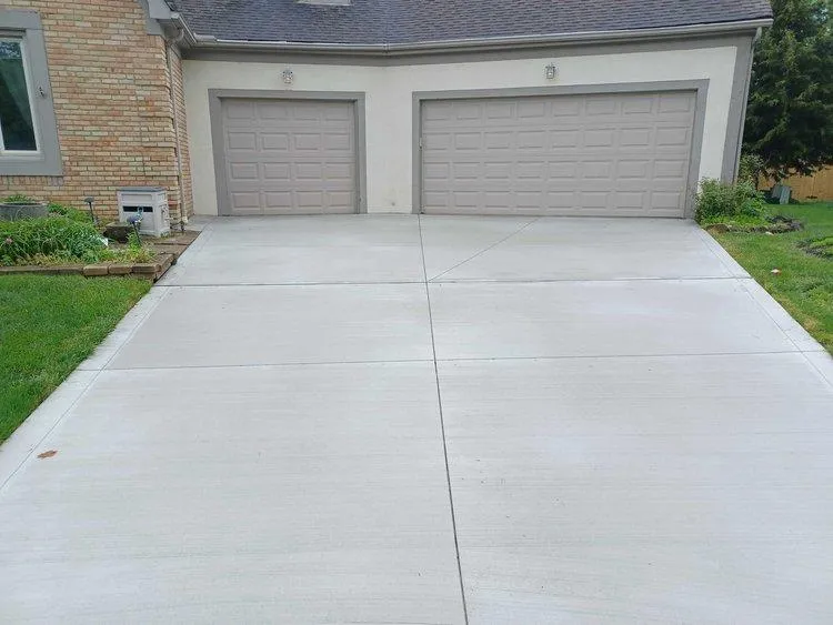 Custom driveway concrete job finished leading to two garage doors in Bexley