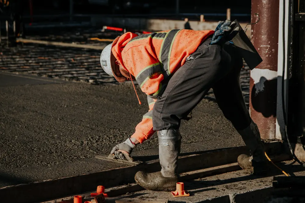 workers leveling freshly poured concrete surface